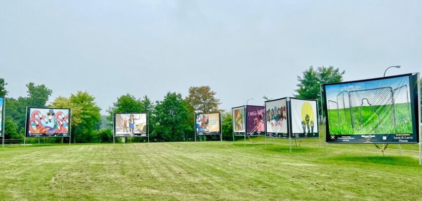 photo of a park and paintings/signs on stands from a distance